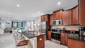 Una cocina moderna con armarios de madera, electrodomésticos de acero inoxidable y una isla central.