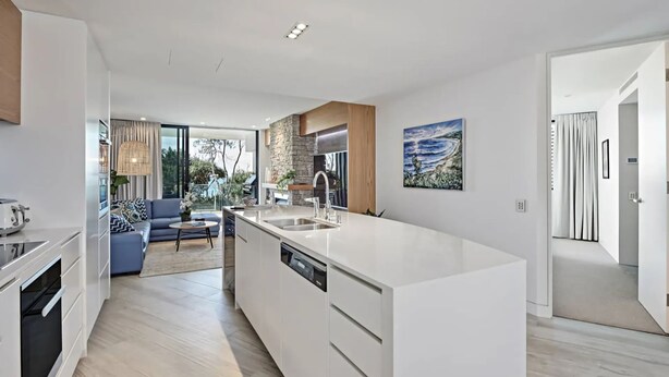 A modern kitchen with a large island, built-in appliances, and a view to the outdoor area. - Byron Bay Accom - Forty Five on Lawson Apt 7 (Byron Bay)