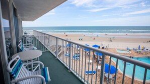 A balcony with a view of a beach and a pool area. - Oceanfront Studio w/ Balcony in Daytona Beach (Daytona Beach Shores)