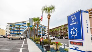 A hotel sign with a blue and white color scheme, indicating a Sea Club IV Resort. - 1BR Oceanfront Condo w/ Full Kitchen & Balcony (Daytona Beach Shores)