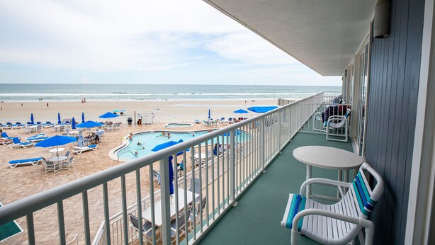 A balcony with a view of a beach and a pool area. - 1BR Oceanfront Condo w/ Full Kitchen & Balcony (Daytona Beach Shores)