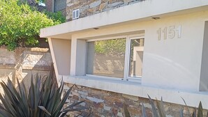 A modern building with a stone facade and the number 1151. - Sea house (Miramar)