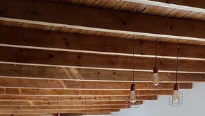 A spacious room with a red sofa, a dining table with chairs, and a wooden ceiling. - Sea house (Miramar)