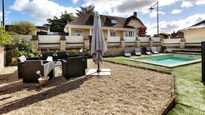 A backyard with a pool, outdoor furniture, and a stone wall. - Holiday Home 'Gîte Le Rabelais' with Private Pool, Private Terrace and Wi-Fi (Thésée)