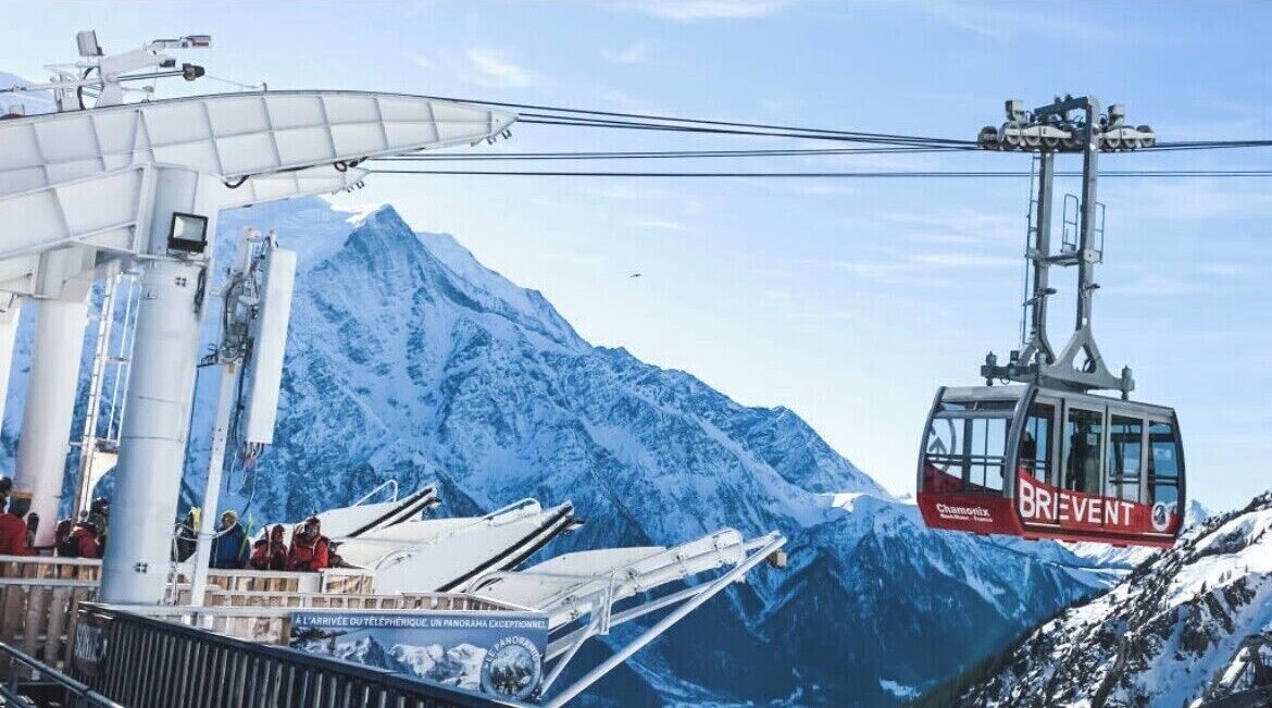 A cable car system with a mountainous backdrop, a gondola labeled "BRIEVENT," and a ski lift structure.