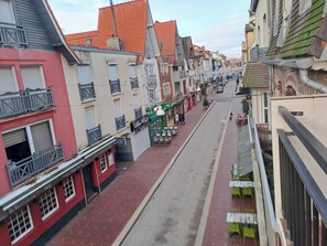 A narrow street lined with buildings, some with balconies and others with shuttered windows. There are outdoor seating areas with tables and chairs. - Bright studio for a relaxing stay in Le Touquet (Le touquet)