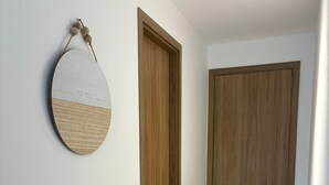 A hallway with a wooden door and a wall-mounted circular decoration. - Espacioso y Confortable Bai Kristal (Cartagena de Indias)
