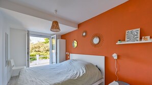 Una camera da letto con un letto, una sedia, una scrivania e una finestra.