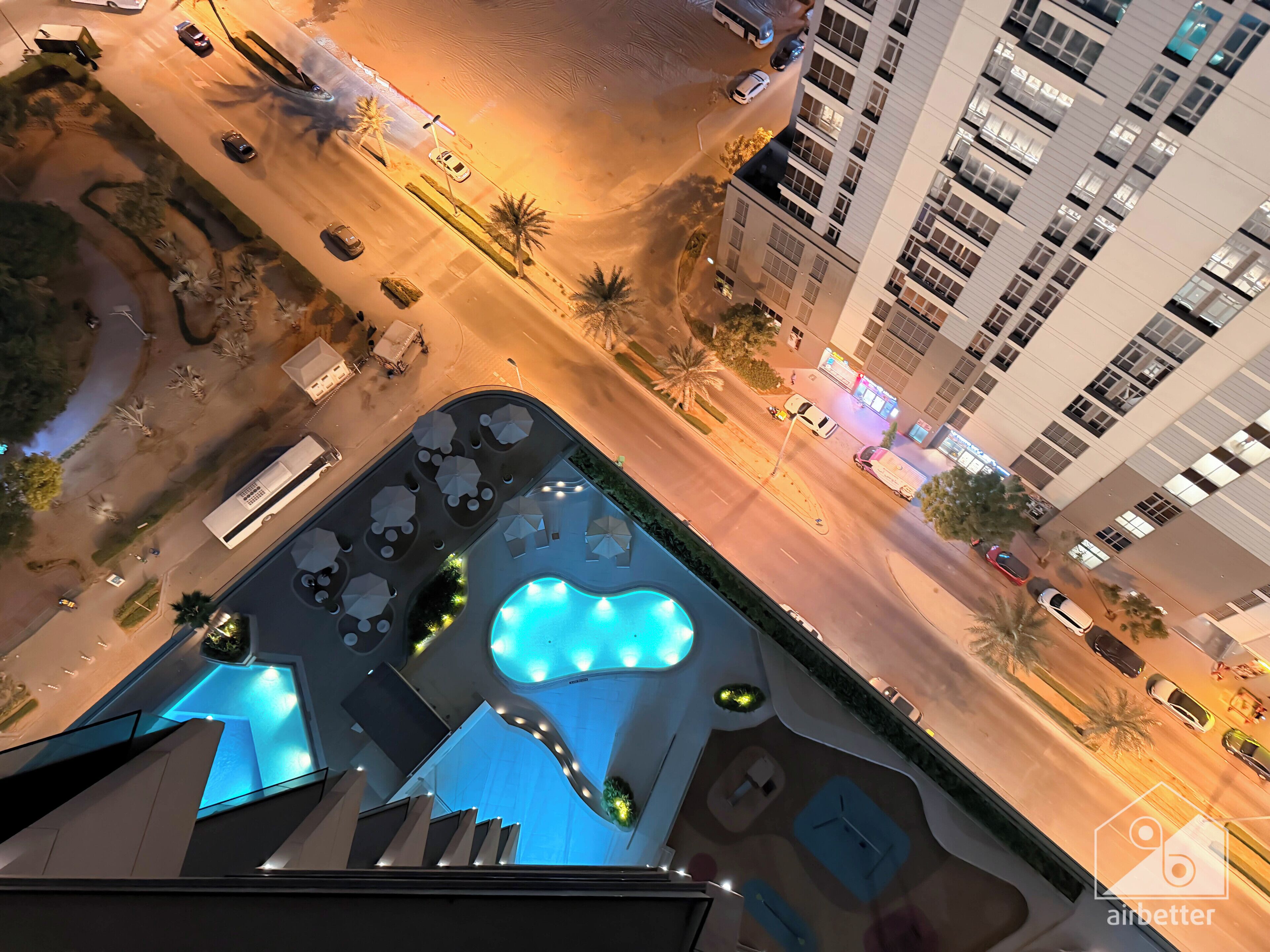 Ein modernes Hotel mit Dachpool, angelegtem Garten und Blick auf die umliegende Stadt.