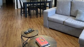 A compact living space with a dining area, kitchenette, and a grey sofa. - Apartamento céntrico en Berga - ALBERGA (Berga)