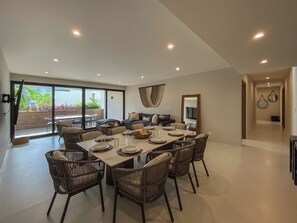 A spacious dining area with a large table set for six, surrounded by wicker chairs. - Almare by Andiani Travel (Cancun)