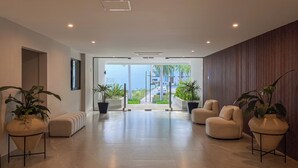 A modern lobby with a spacious layout, a view of the outdoors, and several potted plants. - Almare by Andiani Travel (Cancun)