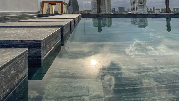 A rooftop pool with a clear view of surrounding high-rise buildings and a cloudy sky. - Almare by Andiani Travel (Cancun)