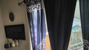 A room with a window, a curtain, a wall-mounted clock, and a chalkboard with writing. - The Wandering Viking! Skal!! (Boise)