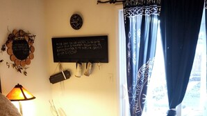 A bedroom with a bed, a ceiling fan, a window with curtains, a wall clock, and a decorative wall piece. - The Wandering Viking! Skal!! (Boise)