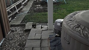 A backyard patio area with a stone pathway, a covered seating area, and a large inflatable pool. - The Wandering Viking! Skal!! (Boise)