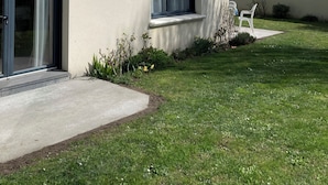 A modern house with a sloped roof, large windows, and a well-maintained lawn.