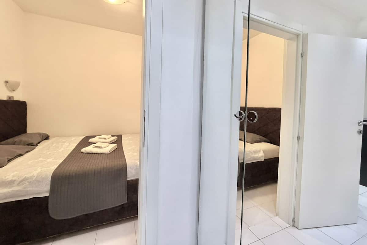 A modern bedroom with a bed, a bedside table, and a wardrobe.