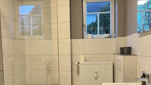 Un baño moderno con ducha, inodoro y lavamanos.