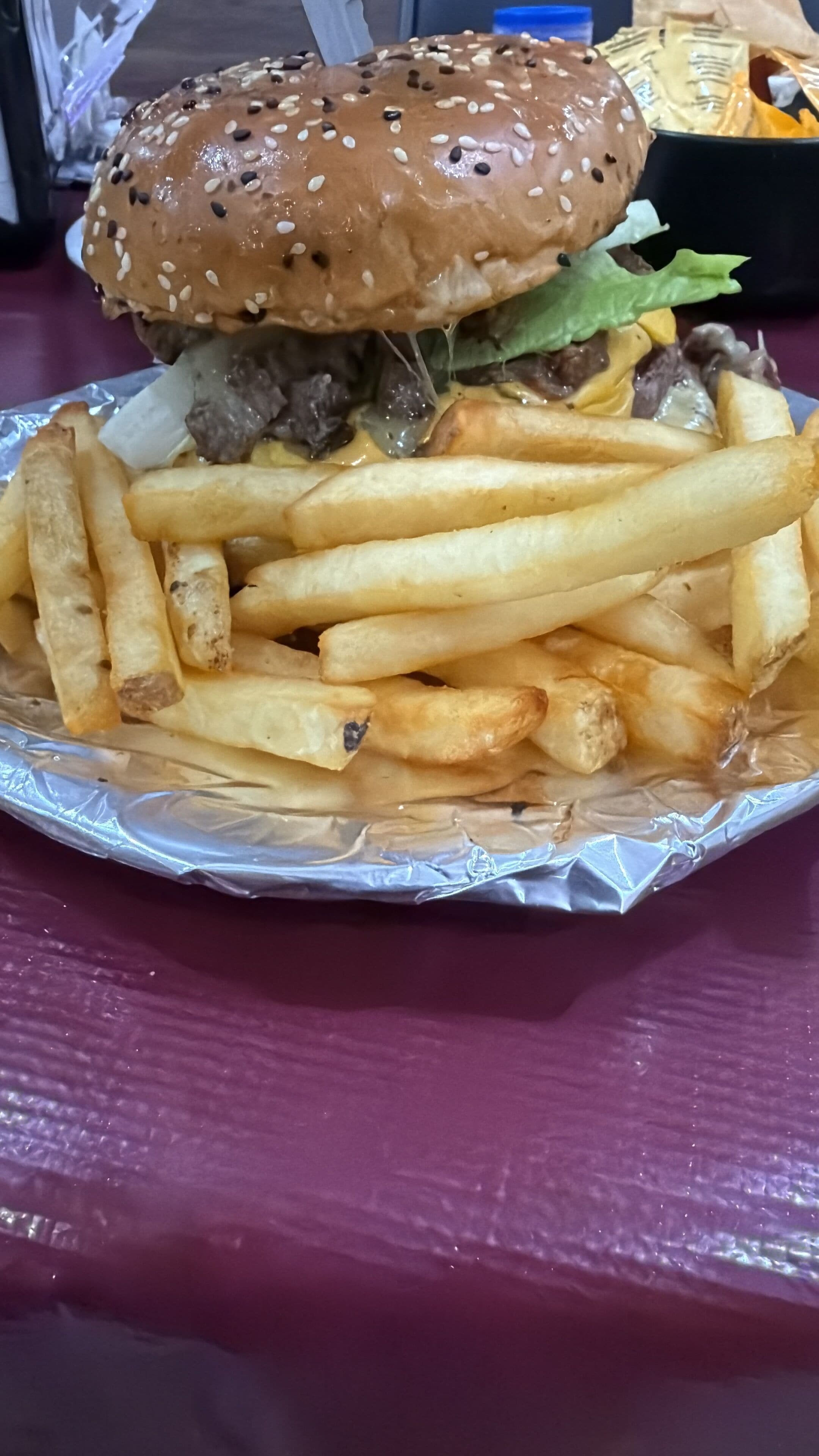 Un hamburger con patatine fritte su un tavolo.
