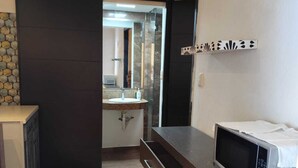 A kitchen with a microwave, a sink, and a cabinet. - Cancún Hotel Boutique & Hostel (Cancún)