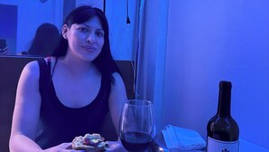 A person seated at a table with a plate of food, a glass of red wine, and a bottle of wine. - Cancún Hotel Boutique & Hostel (Cancún)