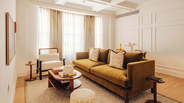 A living room with a sofa, a chair, a coffee table, and a small side table. - SLO Claridge House: 2BR apartment Mayfair (London)