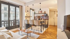 Una sala de estar moderna con sofá, mesa de centro y comedor con sillas y una mesa.