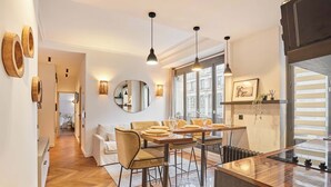 Un comedor moderno con una mesa de madera, sillas e iluminación colgante.