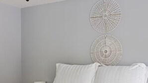Une chambre à coucher avec un lit, deux appliques murales rondes et une lampe de chevet.