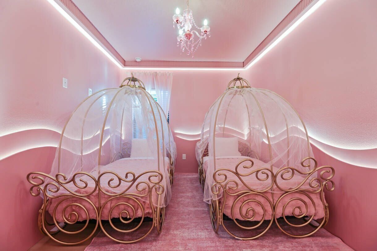 Une chambre avec deux lits, chacun doté d’un baldaquin et d’une tête de lit en métal décorée.