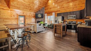 Ein geräumiges Holzblockhaus-Interieur mit Küche, Essbereich und Wohnzimmer.