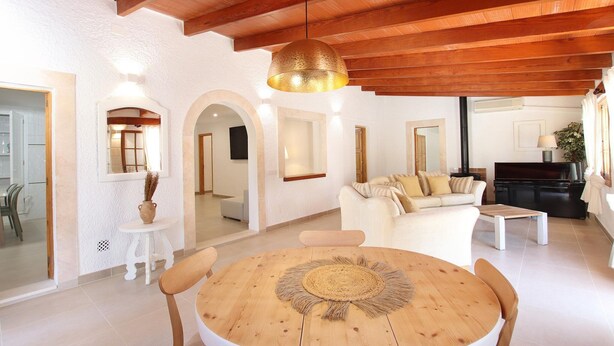 Un salón espacioso con techo de madera, una mesa redonda de madera y un sofá.