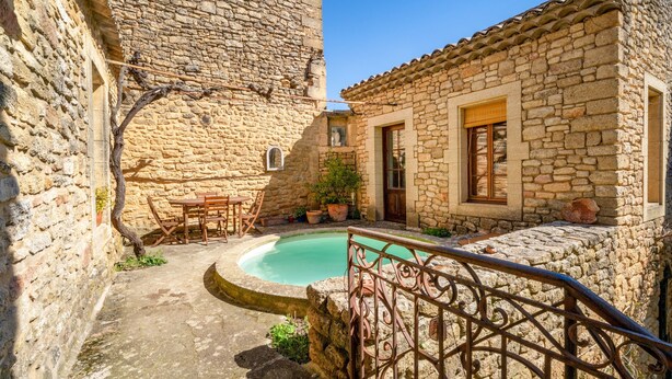 A stone building with a pool, a wooden table, and a metal railing. - Guest Room “Room 1” with Shared Pool, Communal Terrace, and Wi-Fi (Vers Pont du Gard)