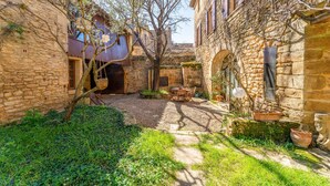 A courtyard with stone buildings, a tree, and a table with chairs. - Guest Room “Room 1” with Shared Pool, Communal Terrace, and Wi-Fi (Vers Pont du Gard)