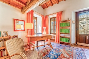 A cozy room with a wooden desk, wicker chair, bookshelves, and a patterned rug. - Bed and Breakfast 'Chambre 2' with Shared Pool, Shared Terrace and Wi-Fi (Vers Pont du Gard)