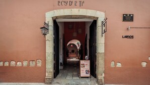 The entrance to Hotel Posada with a stone archway, a signboard, and a plaque on the wall. - Hotel Posada Casa de la Tía (Oaxaca)