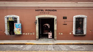 Hotel Posada with a sign above the entrance, a window on the right, and a poster on the left. - Hotel Posada Casa de la Tía (Oaxaca)