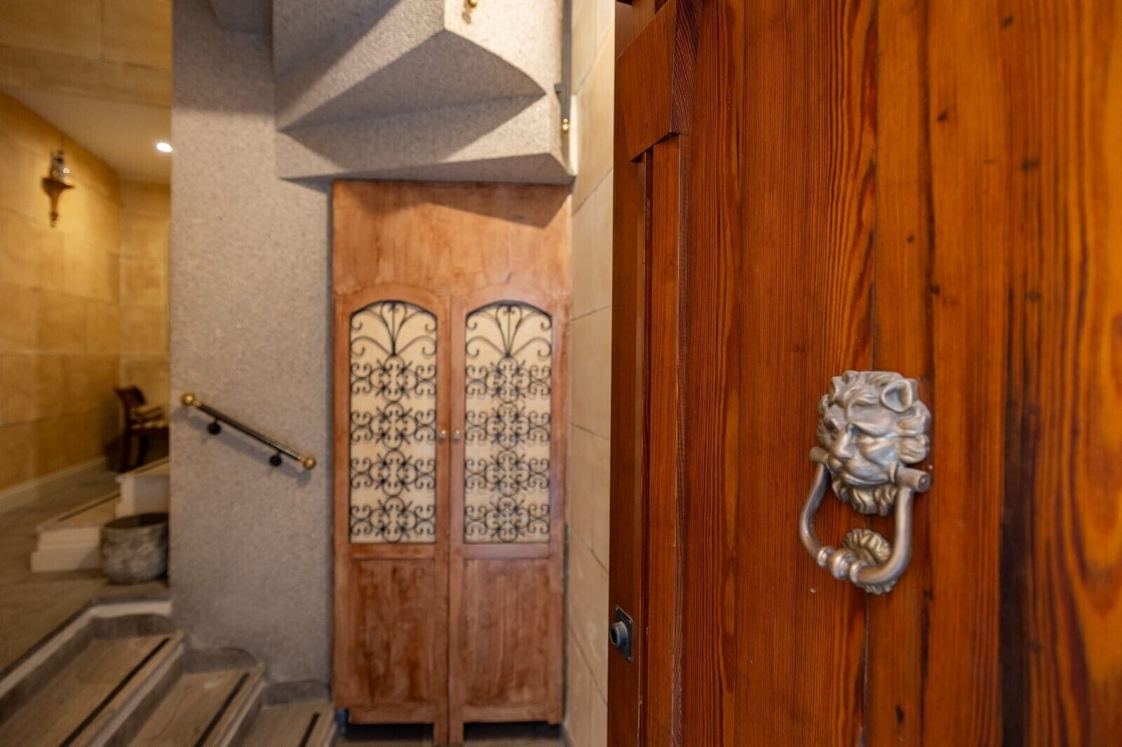 Una puerta de madera con un tirador decorativo y un panel de vidrio con diseños intrincados.