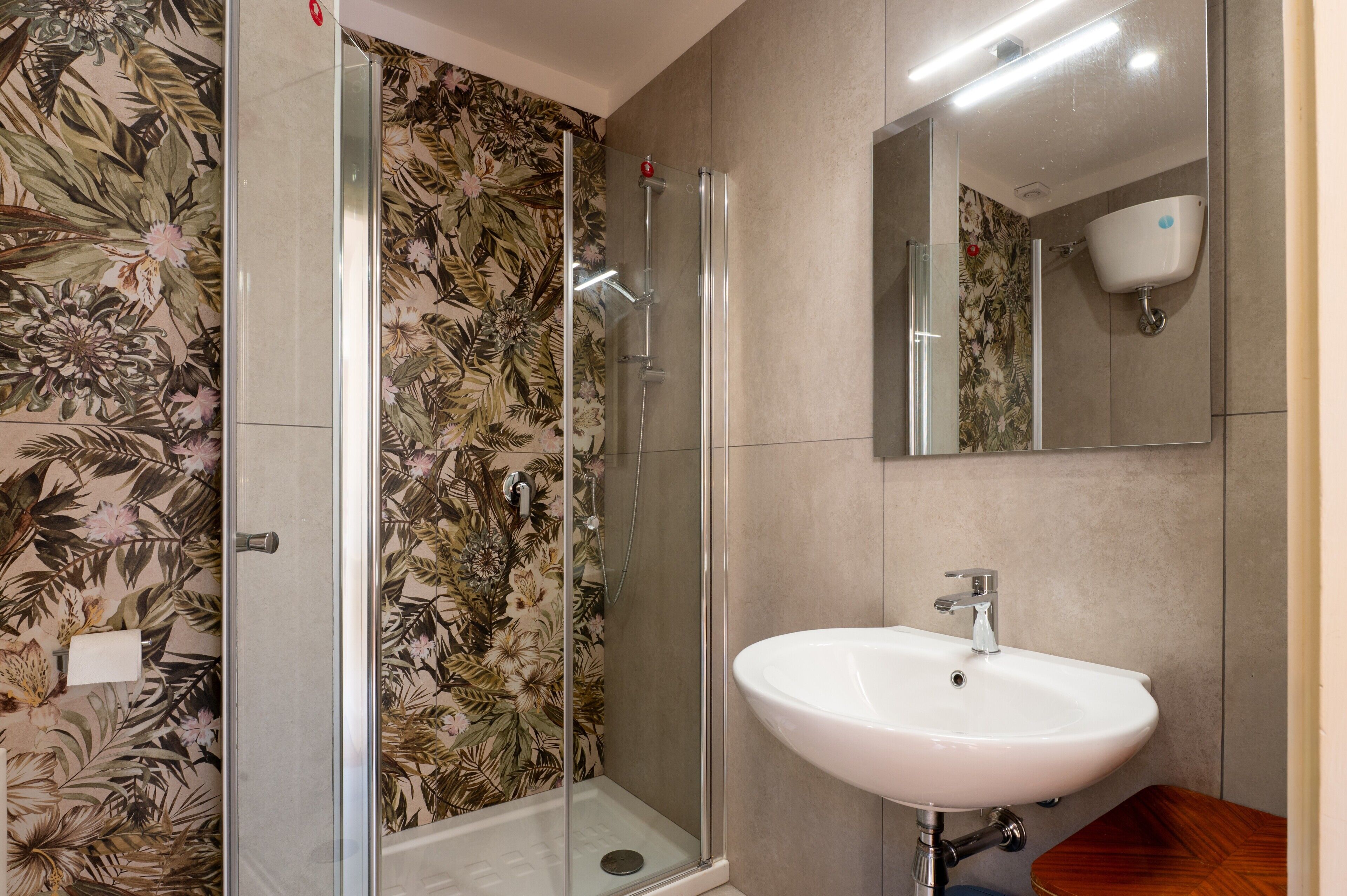 Une salle de bain avec une douche, un lavabo et un miroir.