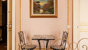 A dining area with a table and chairs, a framed painting on the wall, and a door leading to another room. - Room 'Aurora' at Francy House Termini Imerese (Termini Imerese)