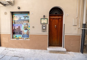 A building with a wooden door, a mailbox, and a poster on the wall. - Room 'Atena' at Francy House Termini Imerese (Termini Imerese)