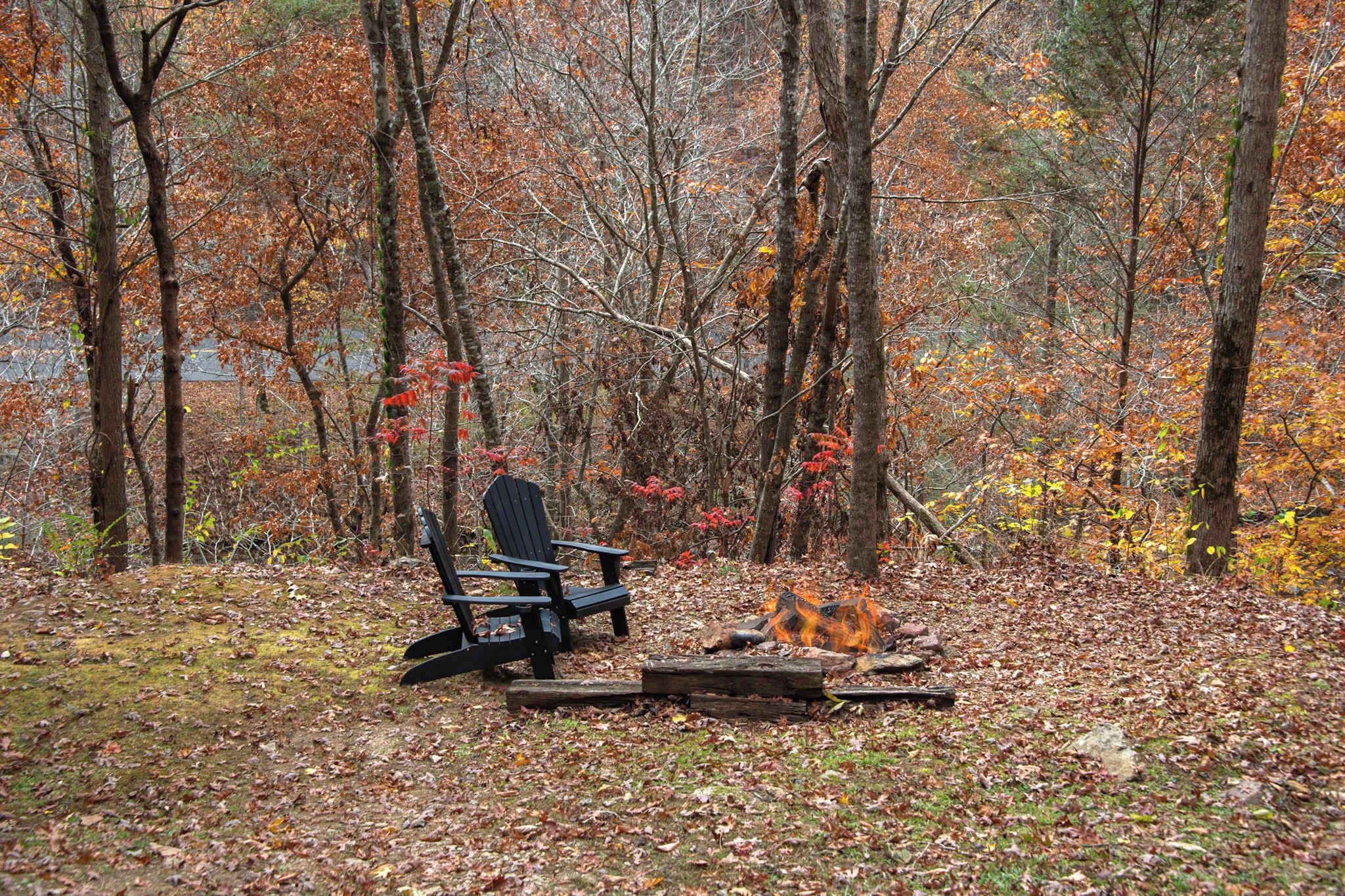 Une scène de forêt avec un feu de camp, une chaise et une bûche.
