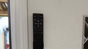 Eine wandmontierte Bedienzentrale mit Tastatur und digitalem Display, vermutlich für ein Hausautomationssystem.