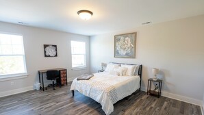 Un dormitorio con cama, escritorio y silla.