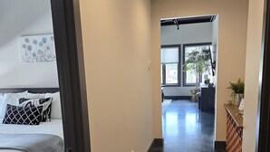 A hallway with a bed, a desk, and a window. - Overlooks downtown Brevard with stunning mountain views! (Brevard)