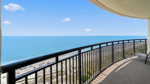 Un balcon avec vue sur la plage et l’océan.