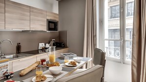 A modern kitchen with a dining area, a large window, and a view of the city. - JUST STEPS FROM THE ICONIC CHAMPS-ÉLYSÉES - SLEEPS 12 -  RUE LA BOÉTIE (Paris)