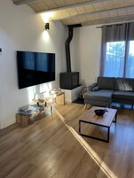 Una sala moderna con una televisión de pantalla plana, una chimenea, un sofá y una mesa de centro.