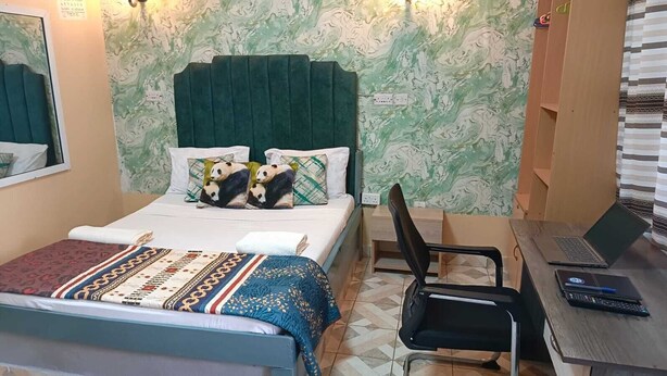 A room with a bed, a desk, a chair, and a laptop. - Enjoyable bed & breakfast in charming Diani near the beach (DIANI)